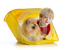 Smiling child and dog in yellow box box isolated on white background