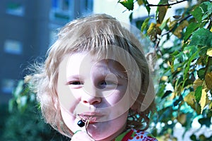 Smiling child eats berries