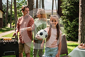 Smiling child with football looking at