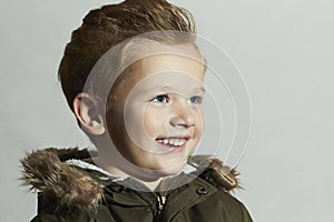 Smiling child.fur hood and winter jacket. fashion kids.children.happy little boy winter style