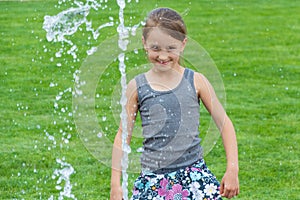 Smiling child girl with water fountain