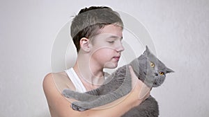 Smiling Child is Holding, Hugging, Kisses a Fluffy Cat in her Arms in Room. 4K