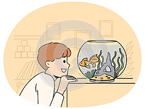 Smiling child look at goldfish in tank