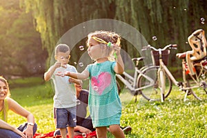 Smiling child playing with soap bubbles in park