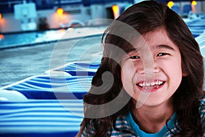 Smiling child by poolside at dusk
