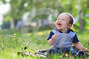 Smiling child seting outdoors in summer park