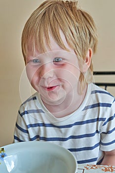 Smiling child sits in front of an empty clean plate