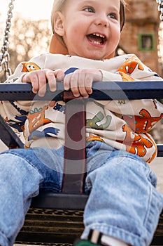 Smiling child on swing with fox-patterned sweater