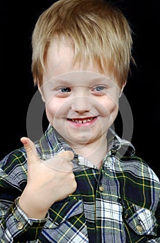 Smiling child with thumbs up sign.