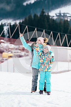 Smiling children enjoying winter vacations in mountains . Ski, Sun, Snow and fun