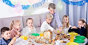 Smiling children having dinner to birthday