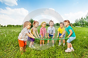 Smiling children holding one hoop together