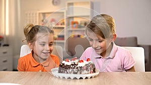 Smiling children looking at chocolate cake on table, childhood happiness, gift