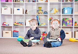 Smiling children reading kids books in play room