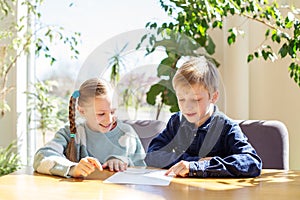 Smiling Children Reading Menu at Brightly Lit Table