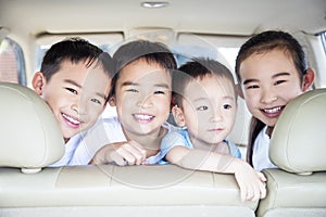 Smiling children traveling by car