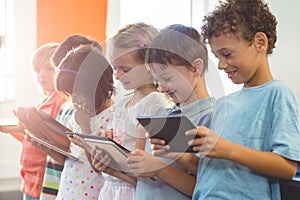 Smiling children using digital tablets