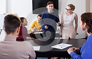 smiling classmates having animated talks at break between classes