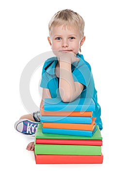 Smiling clever little boy with books