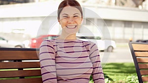 Smiling close up portrait of beautiful brunette young woman smiling in the city. Summer day outside.