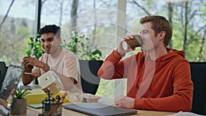 Smiling colleagues drinking coffee enjoying office break closeup. Team talking
