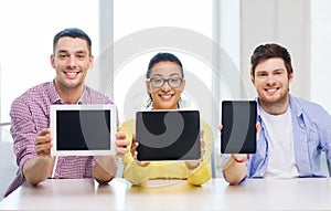 Smiling colleagues showing tablet pc blank screen