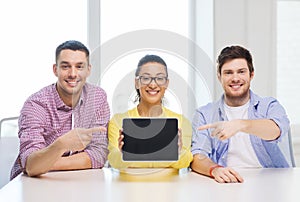 Smiling colleagues showing tablet pc blank screen