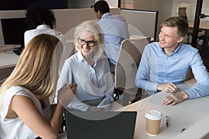 Smiling colleagues talk sharing thoughts at workplace