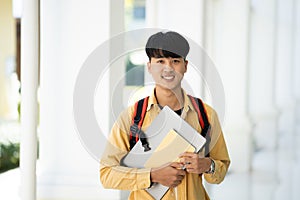 Smiling College Student Holding Books in School Corridor
