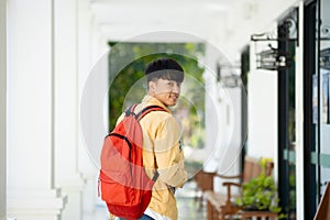 Smiling College Student Holding Books in School Corridor