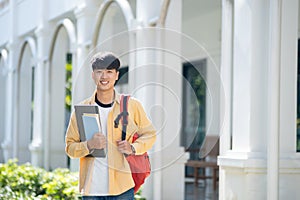 Smiling College Student with Laptop and Books on Campus