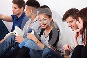 Smiling college student sitting with classmates photo