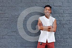 Smiling confident african man standing against gray wall