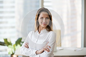 Smiling confident businesswoman looking at camera in office, hea