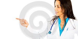 Smiling confident female doctor or nurse or healthcare professional pointing at copy space