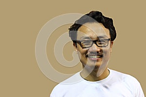 A smiling and confident manipuri north east indian man with spectacles showing the sign of two and victory with fingers