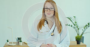 Smiling confident young adult female doctor close up portrait, friendly happy woman physician or nurse professional