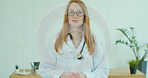 Smiling confident young adult female doctor close up portrait, friendly happy woman physician or nurse professional