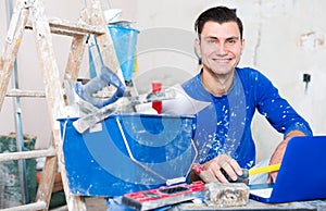 Smiling contractor with papers and laptop