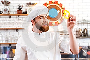 Smiling cook cheif holding slice of yellow bell pepper