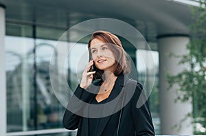 Smiling corporate person with ginger hair in black formal clothes