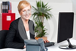 Smiling corporate woman typing on keyboard