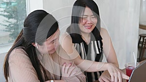 Smiling couple Asian woman is friendship workmate and online shopping in social media platform with smartphone. Technology with