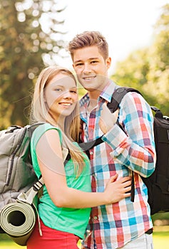 Smiling couple with backpacks in nature