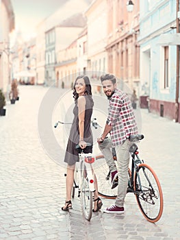 Smiling couple on bicycles in town