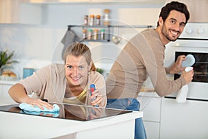 smiling couple cleaning kitchen