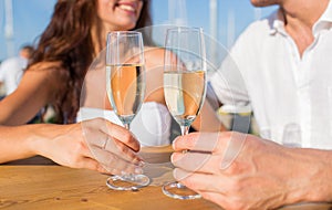 Smiling couple clinking champagne glasses at cafe