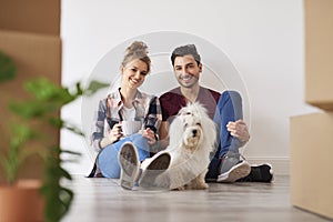 Smiling couple and dog in their new home