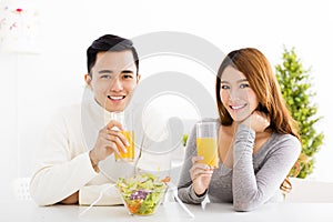 smiling couple drinking juice and healthy food