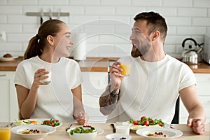 Smiling couple drinking orange juice and buttermilk while enjoyi